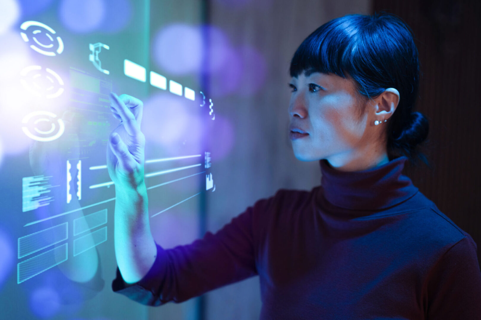 Person interacting with futuristic touchscreen interface.