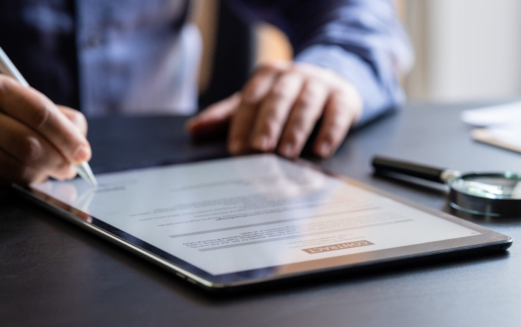 Person signing document on tablet screen.